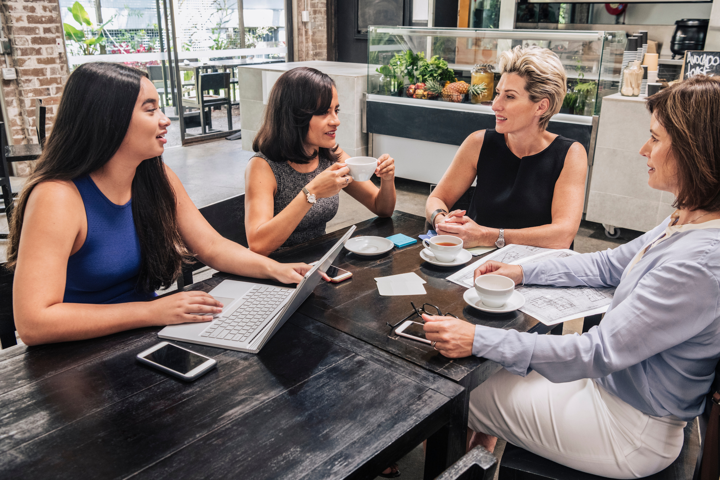 Four women in business meeting at coffee shop